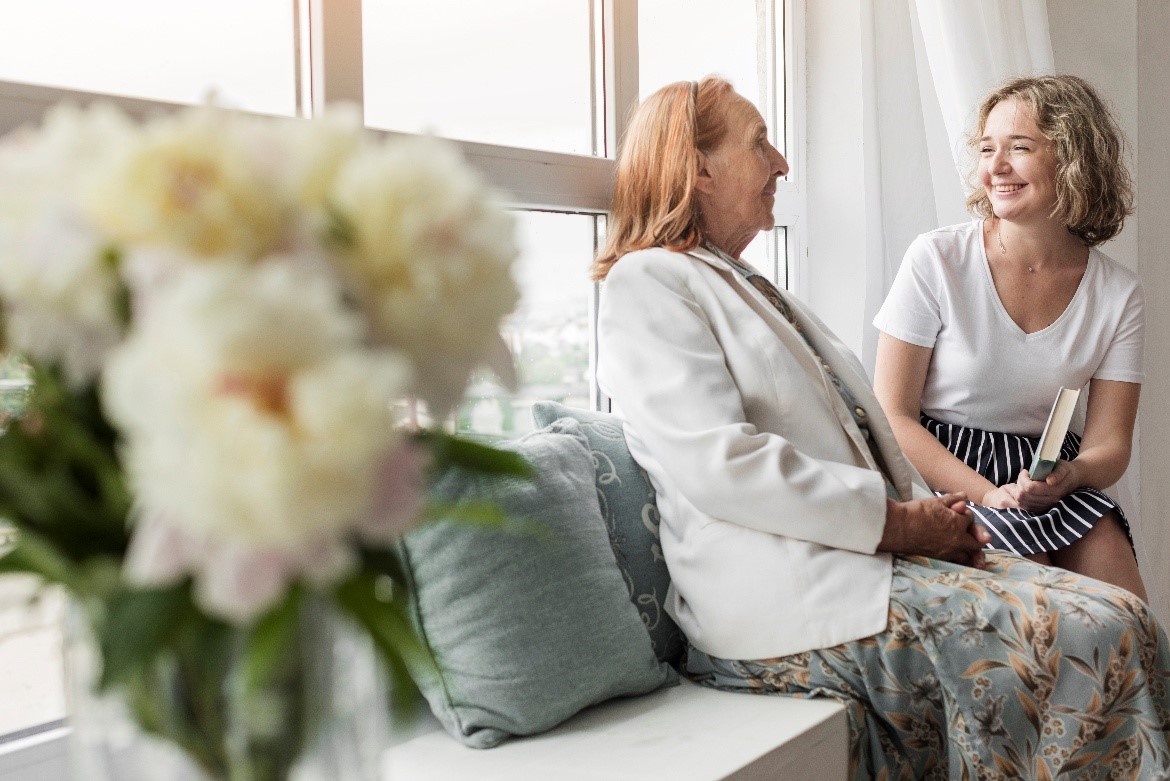A caregiver sharing a warm moment with a client in a bright home setting
